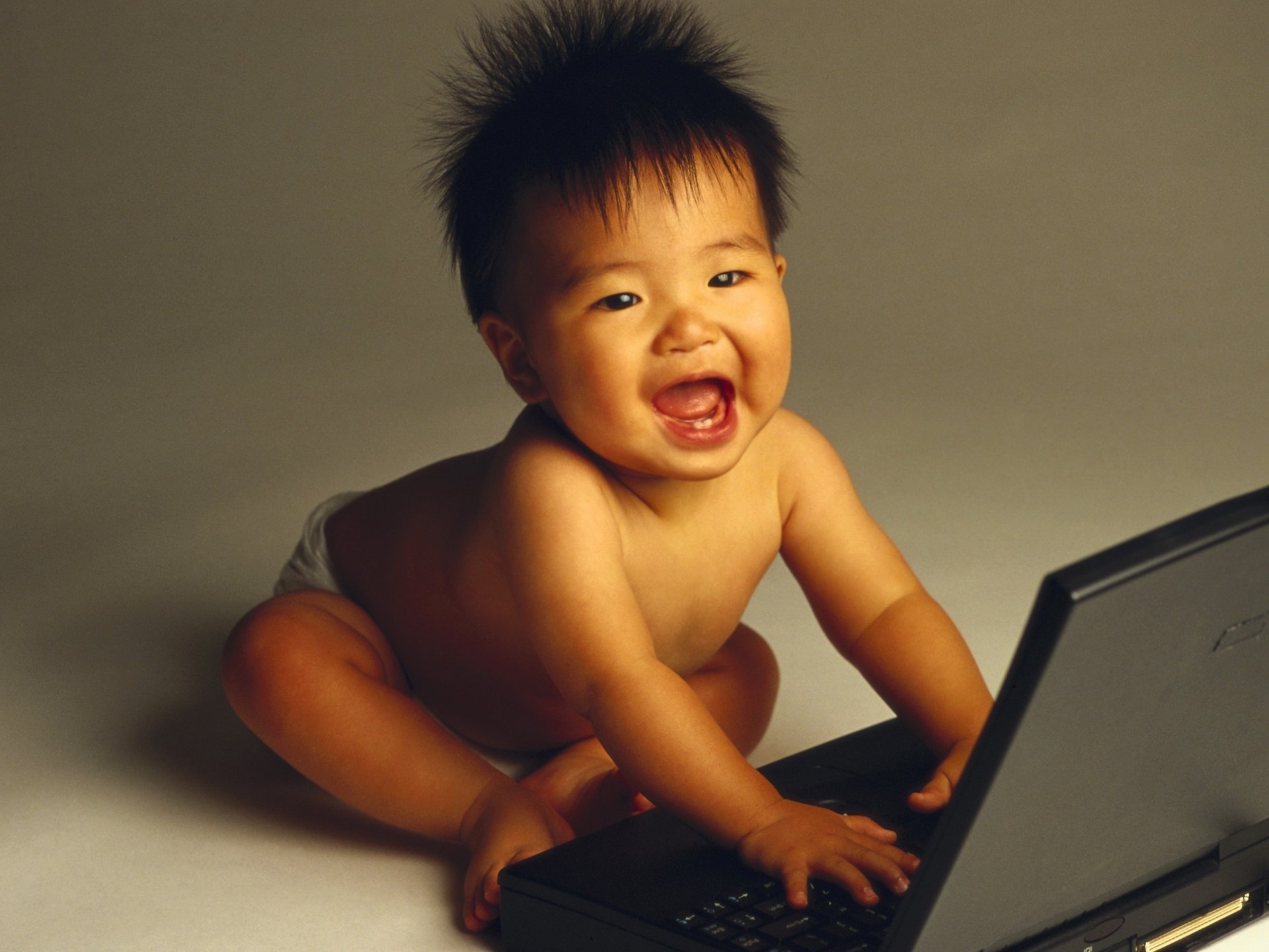 erste zähne kind bewunderung blick lächeln computer laptop asiatisch krümel spiele streiche zappeln spielzeug freude augen gesicht