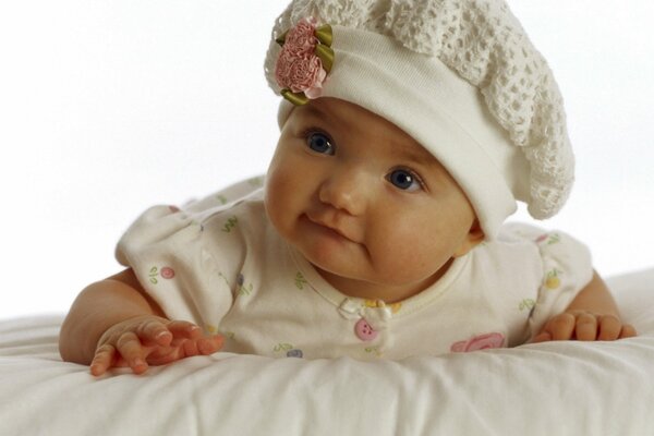 Kleines Baby in einer Mütze mit einer Blume