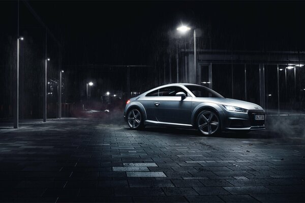 Silbernes Auto nachts unter einer Laterne