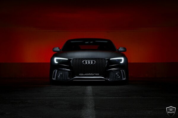 Schwarzer Audi vor dem Hintergrund eines blutigen Sonnenuntergangs