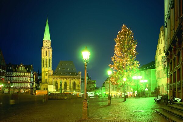 Die Laterne leuchtet hell mit grünlichem Licht auf Häuser und Bäume in der Stadt