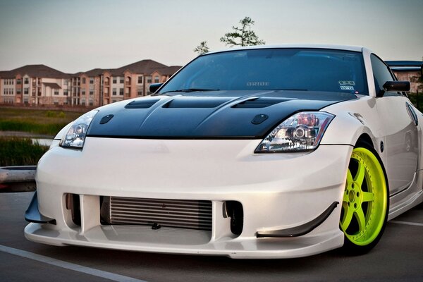 Weißer Nissan-Auto auf dem Hintergrund der Dorfhäuser