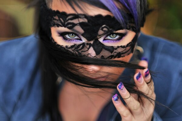 Schönes Mädchen in einer schwarzen Maske