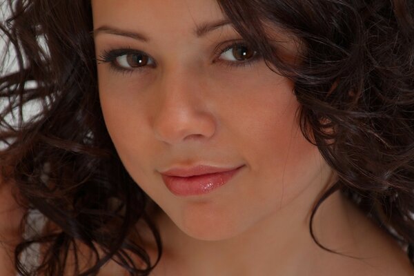 Schönes braunäugiges Mädchen mit lockigem Haar