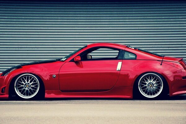 Foto eines roten Nissan 350z auf dem Hintergrund eines geschlossenen Rollators