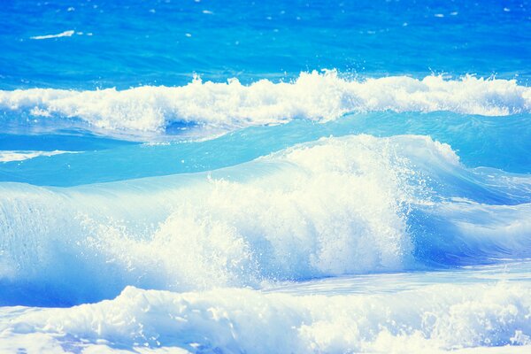 Die Wellen des blauen Ozeans brechen an der Küste auf
