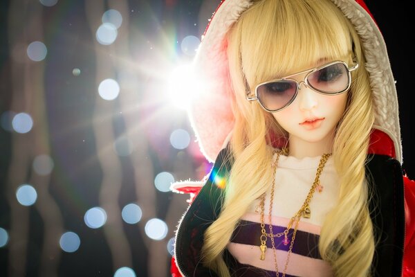 Spielzeugpuppe mit Kapuze und Brille