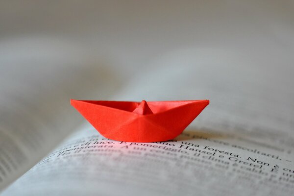 Rotes Boot aus Papier auf der Buchseite
