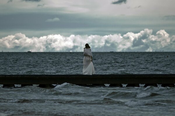 Mädchen schaut auf das tobende Meer