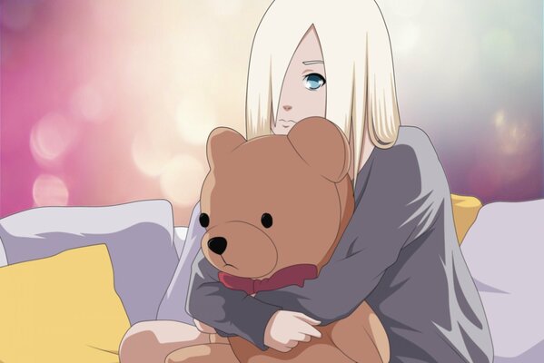 Blondes Mädchen umarmt einen Teddybär