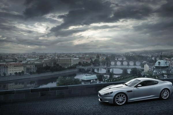 Aston Martin im Hintergrund der Stadt mit Wolken