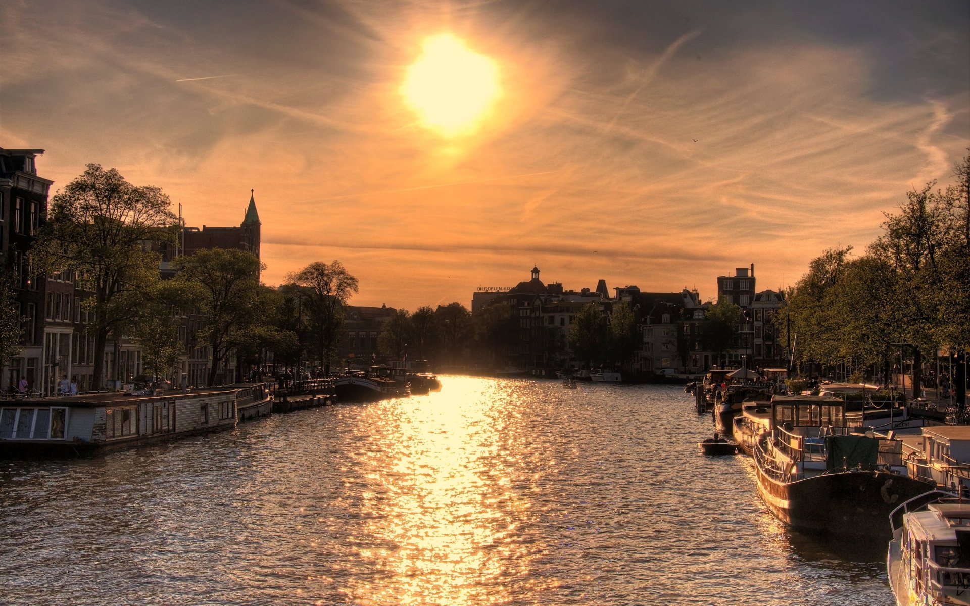 sonne über amsterdam fluss sonne boote zuhause sonnenuntergang