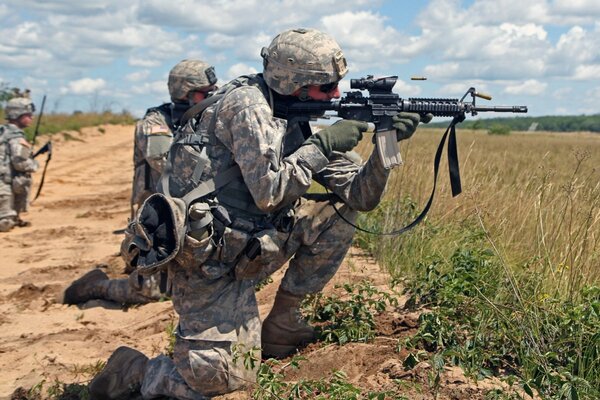 Drei Soldaten mit Waffen im Feld