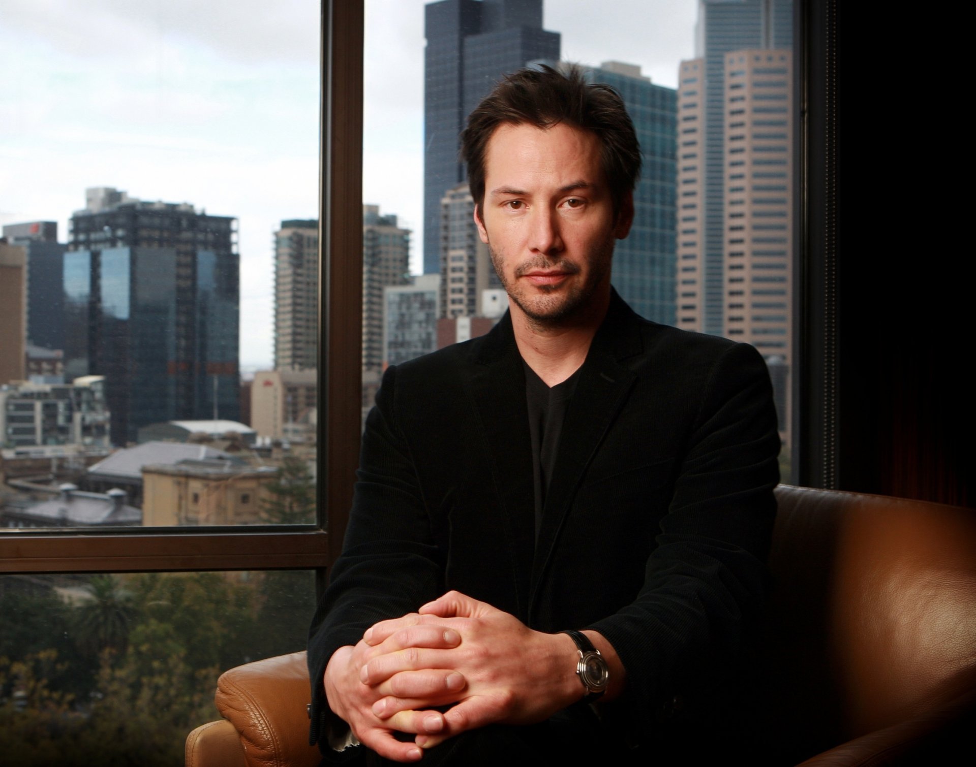 keanu reeves schauspieler sitzen sessel fenster blick stadt