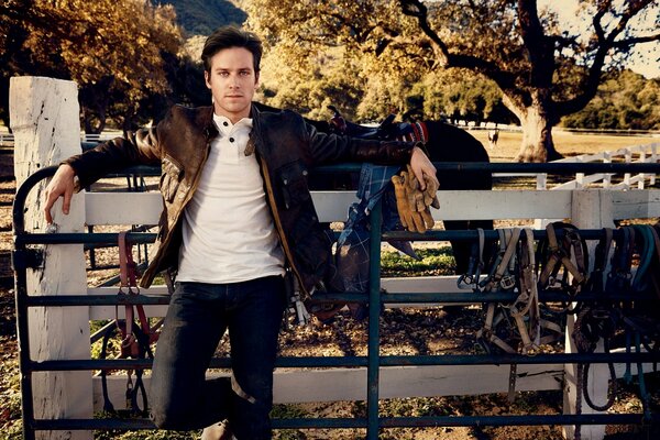 Mann am Zaun neben den Zügeln