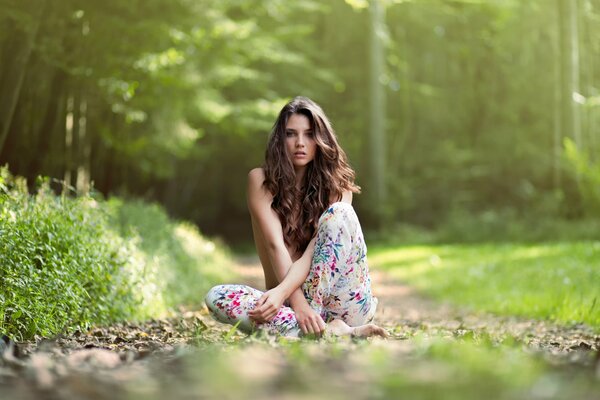 Das Mädchen sitzt inmitten des Grüns