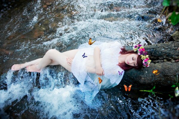 Mädchen mit Schmetterlingen am Fluss