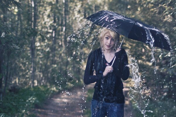 Mädchen unter einem Regenschirm an einem regnerischen Tag