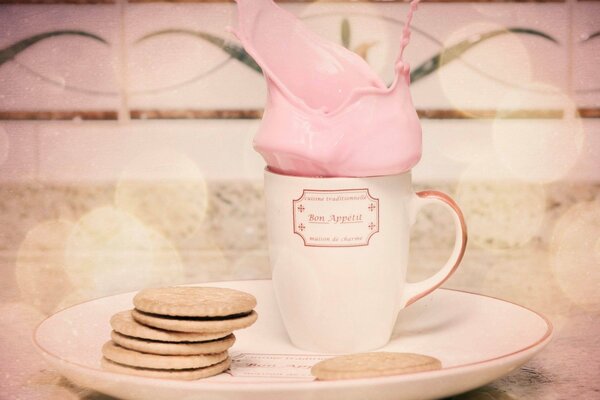 Ein zartrosa Cocktail in einem Keksbecher zum Frühstück
