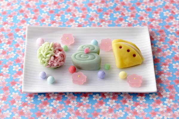 Bunte Marmeladen auf einem Teller auf einem blumigen Hintergrund