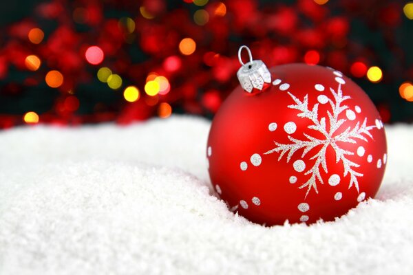 Rote Weihnachtskugel im Schnee